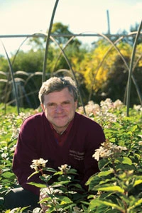 Man posing in front of flowers