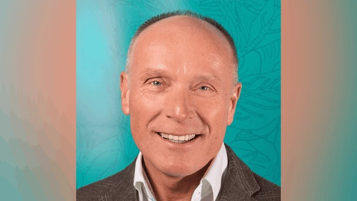 Head shot of a man in button down against teal background