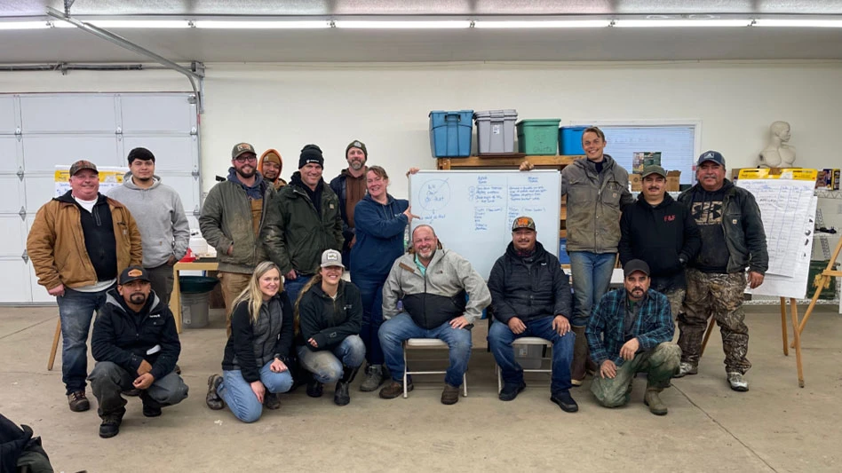 Group of people posed around a whiteboard.