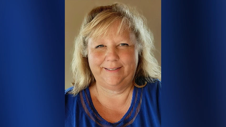 A woman wearing a blue shirt smiles in a headshot photo.
