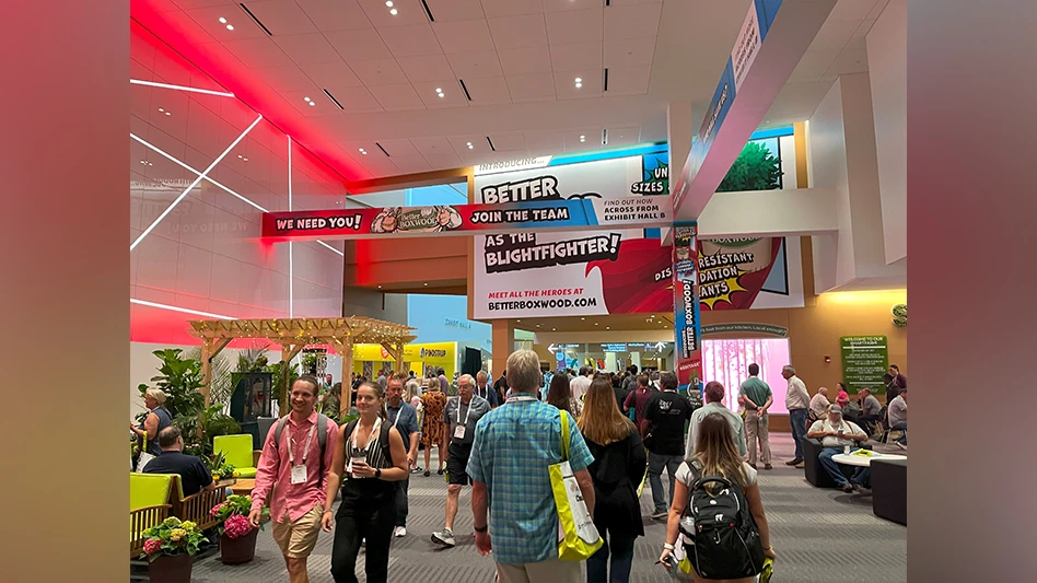 a crowd of people walk around a convention