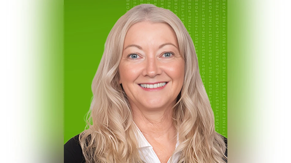 A photo of a smiling woman with long gray hair in front of a bright green background.