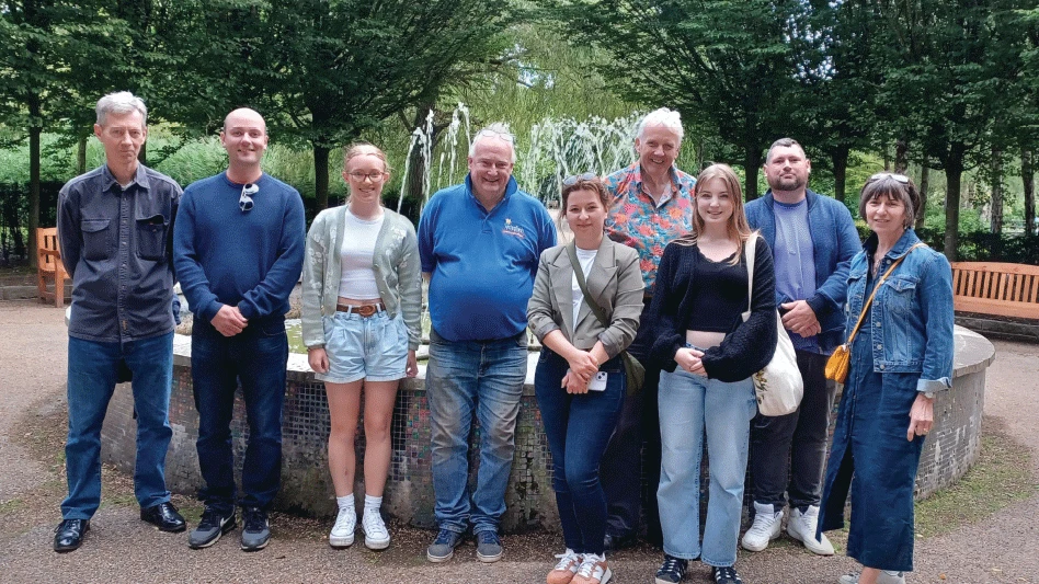 Group of people pose together wearing blue clothes.