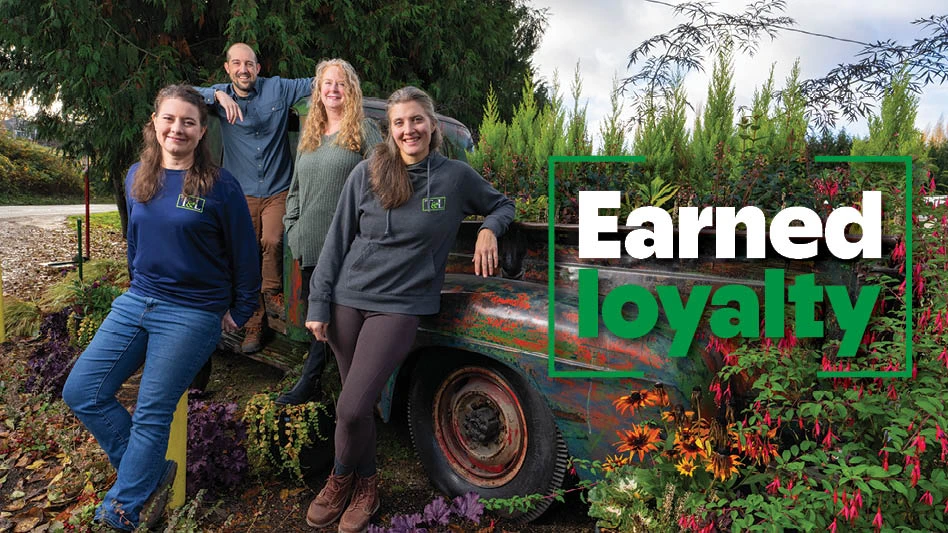 A group of men and women leaning on a truck at a wholesale nursery.
