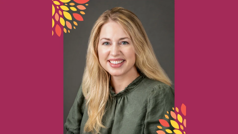 A headshot photo of a smiling woman with long blonde hair wearing a gray top against a gray background. The background around the image is maroon.