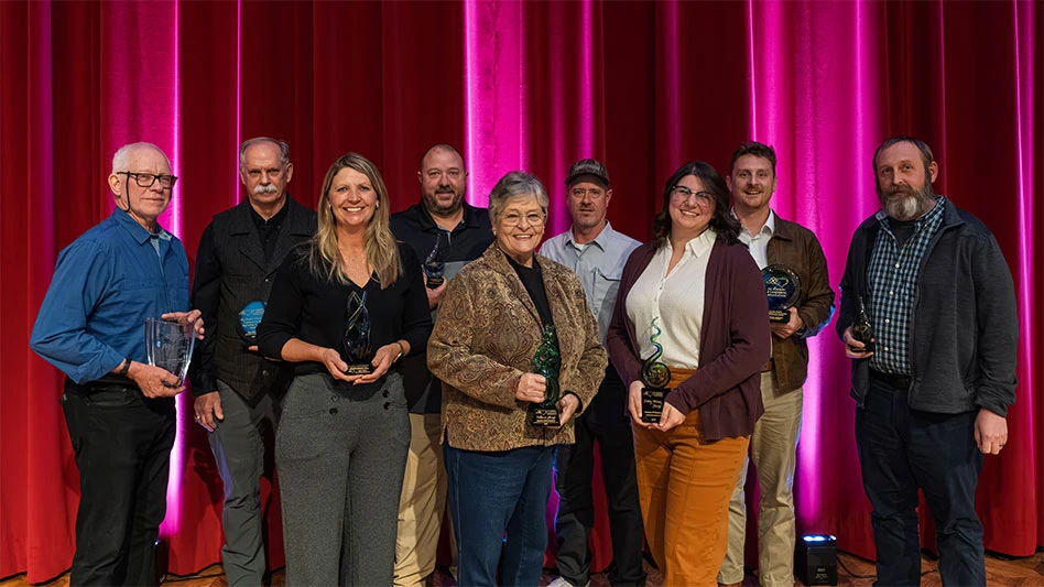 A group of people on a stage holding awards.